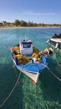 Charming fishing boat in clear waters of Agios Arsenios, Naxos, Greece