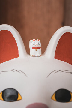 Miniature Lucky Cat Figurine on Giant Cat Statue