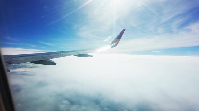 Wing of plane with blue sky and clouds