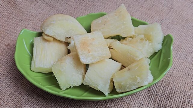 Fried cassava is served on a green leaf-shaped plate, usually served for breakfast or as a snack to accompany tea or coffee.