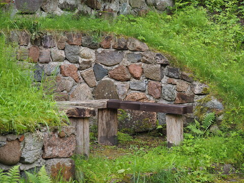 A wooden bench against a stone wall