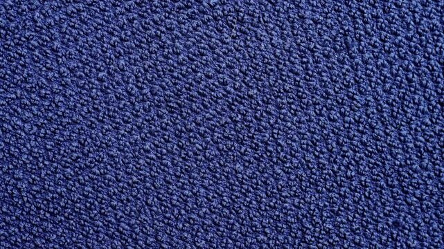 Soft blue terry towel texture with looped cotton fibers creating an even absorbent surface. Detailed textile background with fabric structure. Rotation