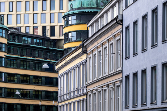 Seen through a compressed frame, repeated windows follow gentle curves above a street in Oslo, Norway, while historic facades shape layered modern architecture.