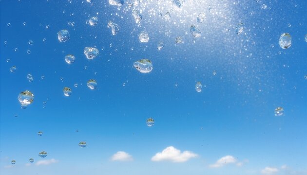 青空と太陽の光を背景にキラキラと輝く大粒の水の滴と水しぶき　Sparkling Large Water Droplets and Splashes against a Clear Blue Sky