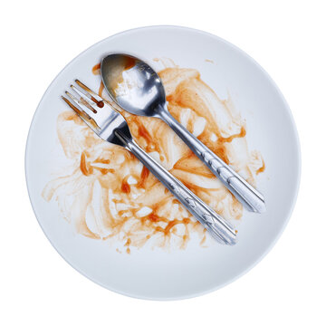 round white plate,fork and spoon stained with red sauce after finishing meal isolated on white.
