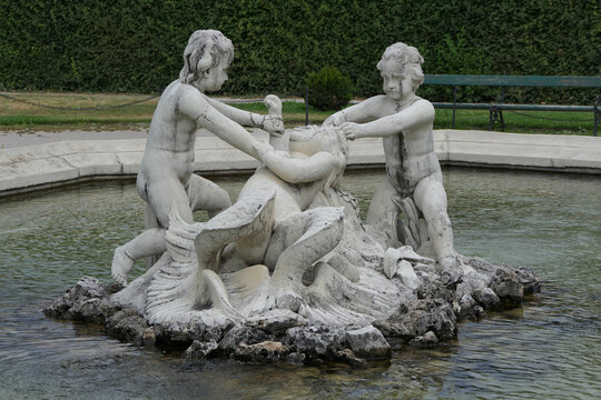 Baroque fountain sculpture with cherubs and fish in the Belvedere Gardens, Vienna, Austria. 