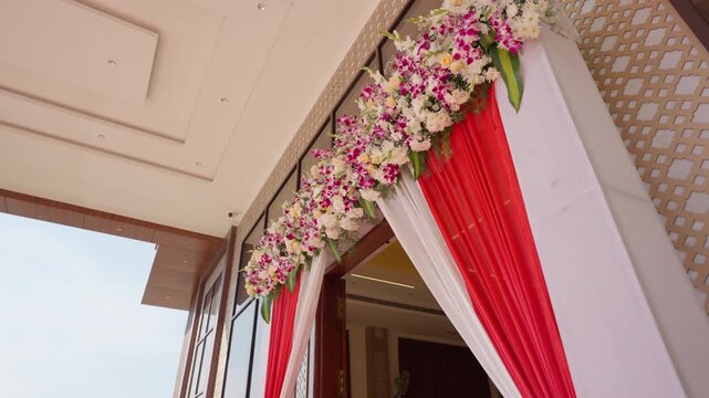 Looking up at elegant flower garland and fine fabric curtains decorating modern event venue entrance