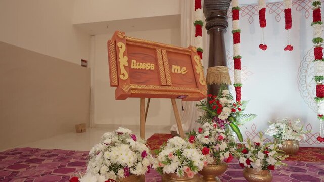 Floral bouquet decorated stage event venue with guess me baby name ceremony board displayed