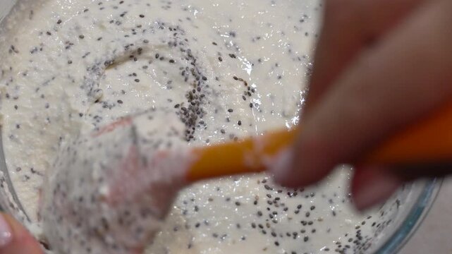 Chia seed pudding preparation in a glass bowl. Close-up high angle shot.
