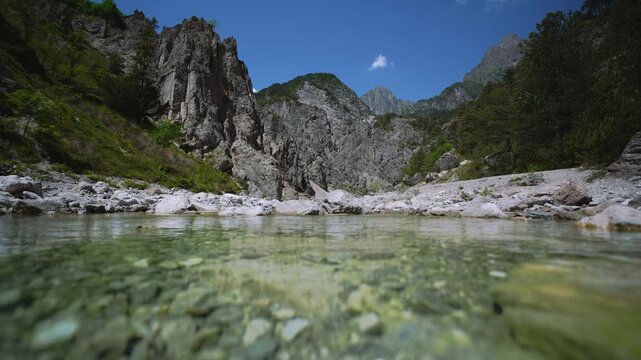 Close-up of transparent mountain river water flowing with rocky dolomites in Andreis, Northern Italy