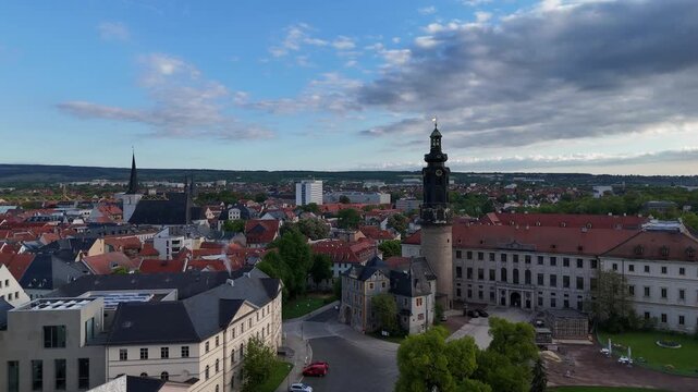 Drone camera flying toward Duchess Anna Amalia Library and nearby palace buildings at sunrise
