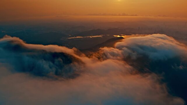 Sunrise over misty mountain peaks and rolling clouds