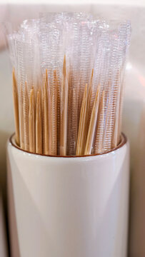 Individually wrapped wooden toothpicks in a ceramic holder, emphasizing restaurant hygiene, dental care, and oral cleanliness after dining out