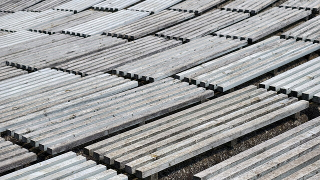 Grey wooden planks arranged in a repeating geometric grid, showing weathered texture and parallel lines, creating a structured background and abstract surface