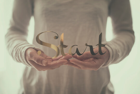 Close-up of a Woman in casual clothing holding a decorative word start
