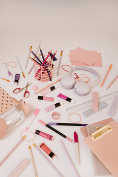 Aesthetic Pastel Pink School Supplies And Creative Art Tools Scattered On White Surface With Wireless Headphones