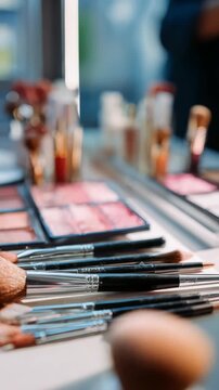 A collection of makeup brushes and cosmetic products arranged neatly on a white surface. The image captures the essence of beauty preparation and artistic makeup application