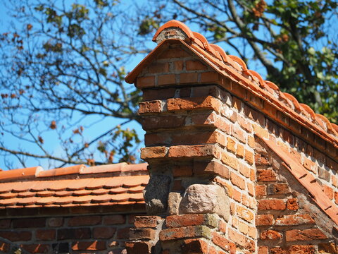 Red brick wall and triangular roof tiles