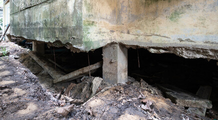 Fototapeta premium Crack and damage beneath a building in a residential area, showing the ground erosion and structural concern
