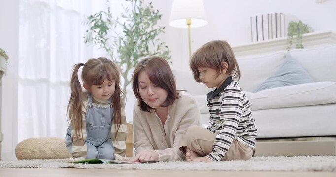 Single mother smiles while guiding preschool son, toddler daughter during playtime, kids creative play with toy blocks and picture book, sibling bonding, emotional support, family happiness at home.