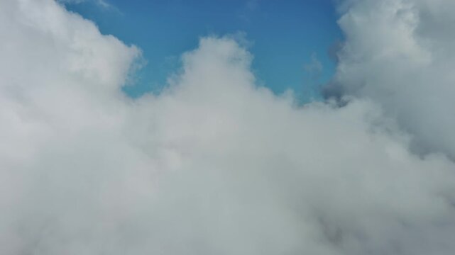 Aerial high view of clouds and blue sky, flying in clouds, 4k