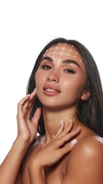 Young brunette woman with animated face and neck grid in radiant beauty portrait. Concept of virtual beauty consultation, facial rejuvenation visualization, cosmetic procedure simulation.