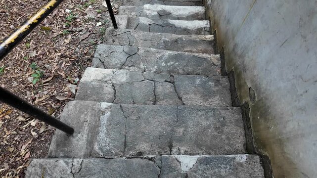 A Person Walking Down Old Concrete Staircase.