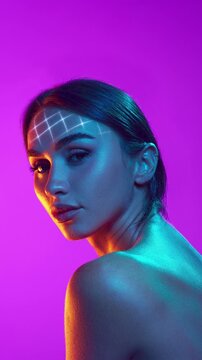 Futuristic brunette woman with animated facial scan grid under vibrant neon light. Concept of AR makeup testing, biometric identity interface, immersive beauty campaign.