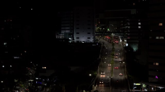 Aerial Night View of Busy Urban Avenue and Illuminated Bridge
