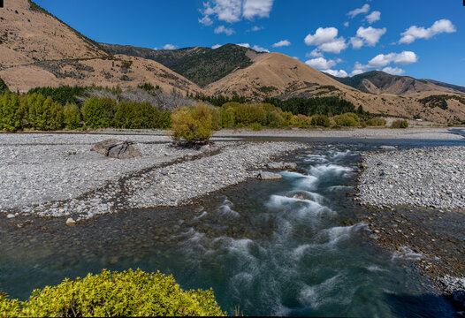 Wairau River Kiesbett mit tuerkisfarbenen Stromschnellen vor goldenen Tussock Huegeln im Marlborough Distrikt Neuseeland