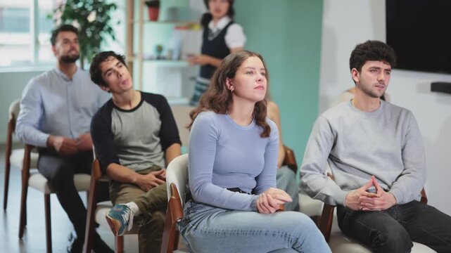 Woman gives a presentation to a small audience in a modern office and classroom. Young teacher showing materials to students in class