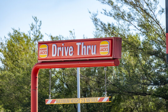 Hungry Jack's "Drive Thru" entrance overhead sign with a suspended height clearance bar reading "MAXIMUM HEIGHT 2.6 METRES" in Melbourne Australia.