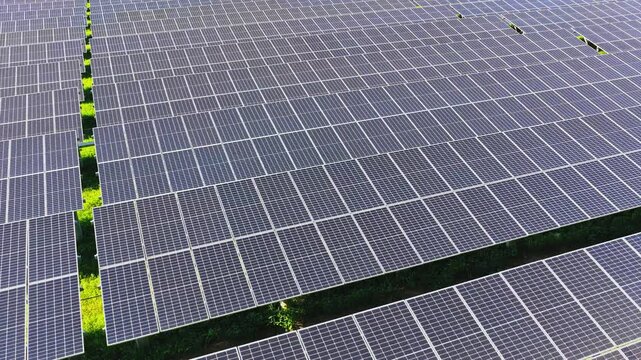 Top down drone view gliding over a grid of solar panels