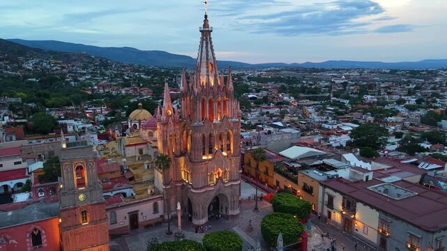A cinematic aerial perspective capturing the intricate architectural splendor and soaring neo-Gothic towers of the Parroquia in San Miguel de Allende.