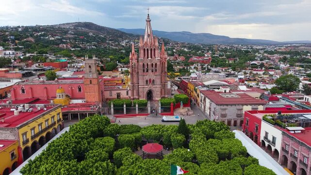 A cinematic aerial perspective capturing the striking neo-Gothic facade and soaring masonry of the historic Parroquia de San Miguel Arc&aacute;ngel.