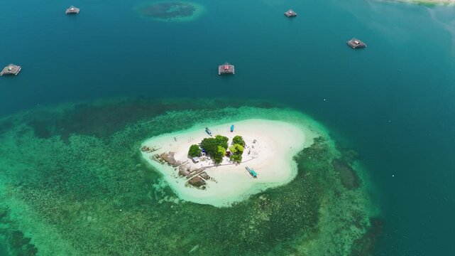Aerial View, Gili Kedis, Lombok, Indonesia, showcasing a tiny tropical island surrounded by crystal-clear turquoise water, coral reefs and fishing platforms