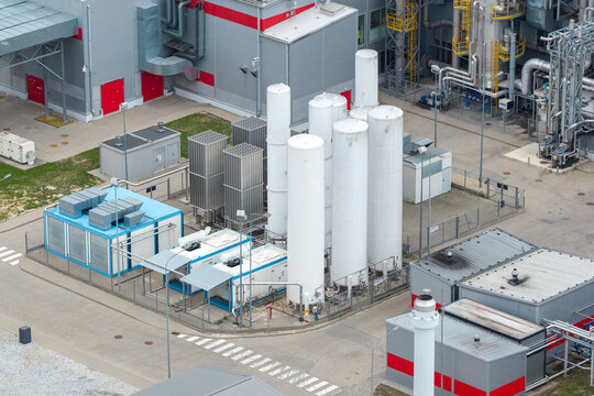 Aerial view of an advanced food production facility featuring tall white liquid gas storage tanks, industrial piping, and modular cooling units in Poland.