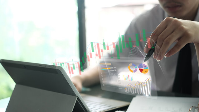 A businessman points a stylus at holographic stock trading charts and data analytics on a tablet. Ideal for financial technology blogs, stock market courses, and investment platform banners.