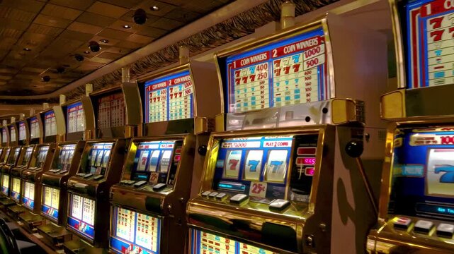 Row of slot machines in a casino, dynamic motion footage with bright lights and gaming entertainment.