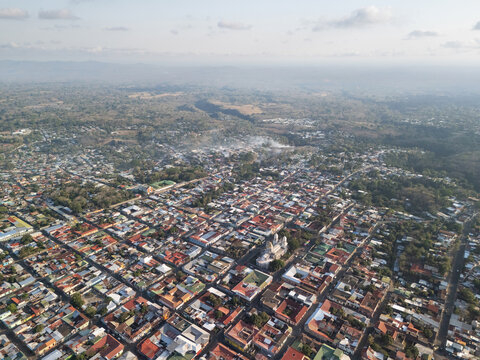 Aerial view of the city of Jinotepe, featuring the central church, dense residential rooftops, and surrounding lush landscape in Jinotepe, Carazo, Nicaragua.