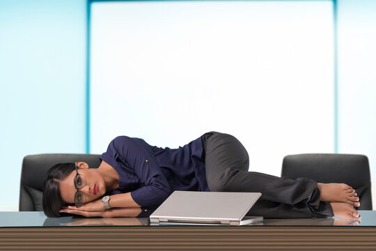 Businesswoman lying on desk in office