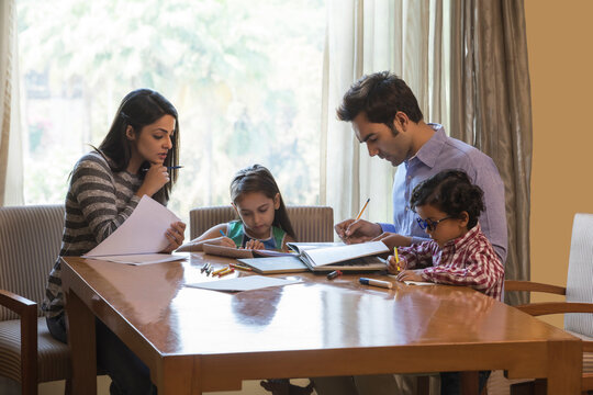 Parents helping daughters with homework