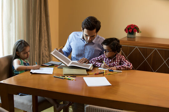 Father helping children with homework