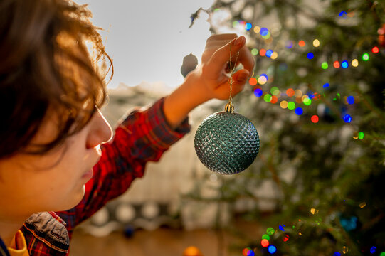 Boy decorating Christmas tree at home