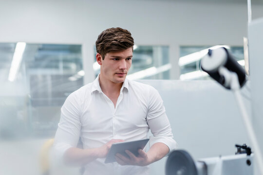 Male engineer with digital tablet working in factory