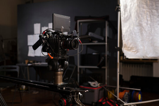 Professional cinema camera on a slider in a dark studio setting