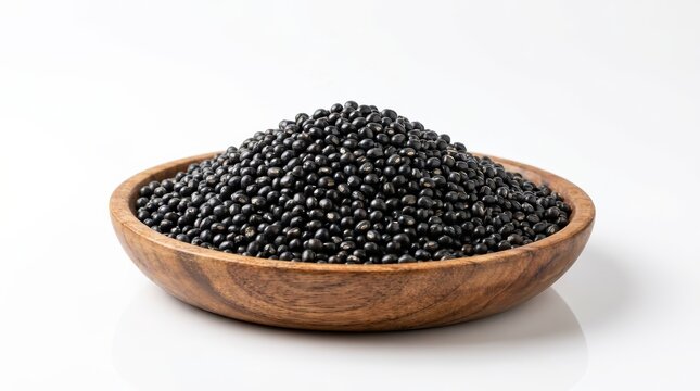 Black urad dal lentil beans piled in a wooden bowl isolated on white background.