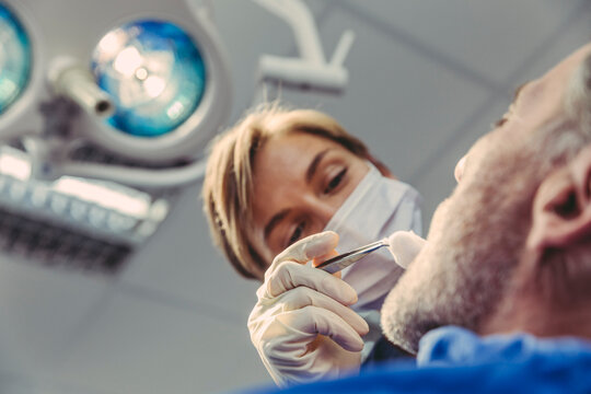Dental surgeon during surgical procedure on a patient