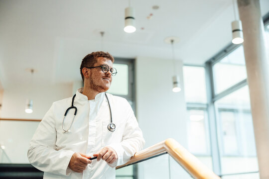 Doctor with stethoscope standing indoors at hospital looking confident