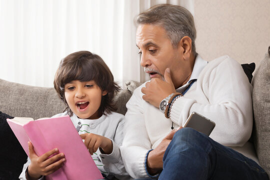 Grandfather and grandson shocked while reading book